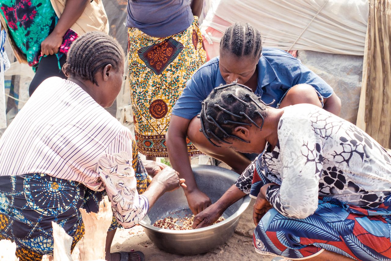 Mastering the First Impression: Your intriguing post title goes here Group of women collaboratively sorting beans outdoors, showcasing cultural richness.